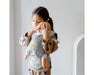 caption-Child holds play doll in Lillebaby Doll Carrier