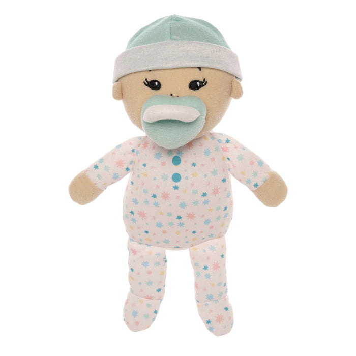 Stuffed toy baby doll with pacifier and polka dot outfit on a white background