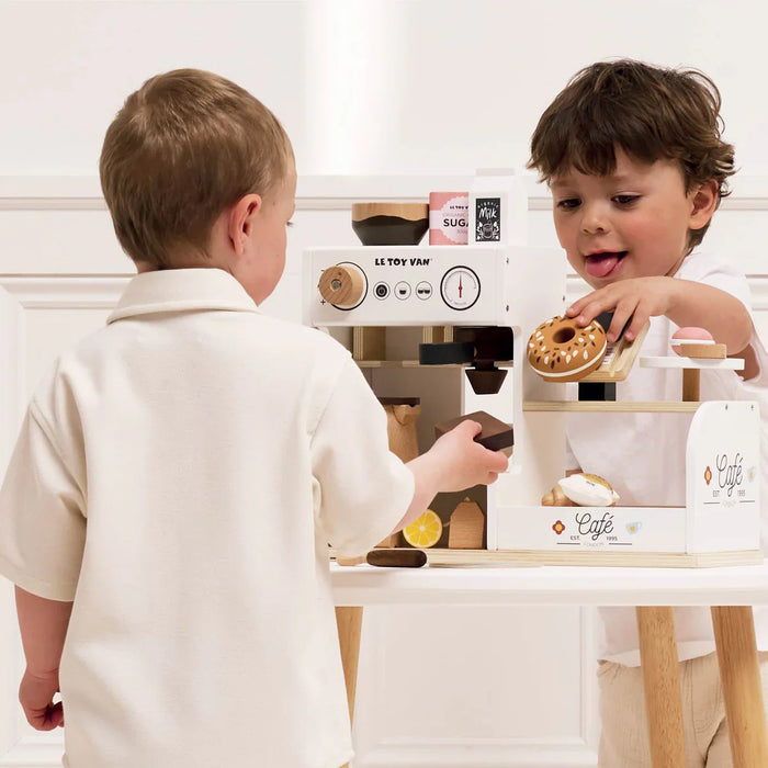 Two kids playing with a cafe set