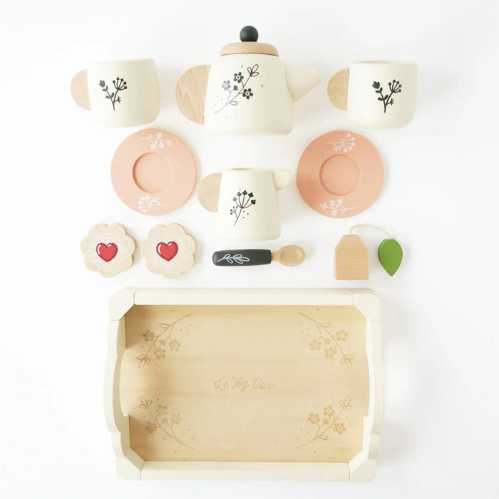 Children's tea set with teapot, cups, and cookies on a white background