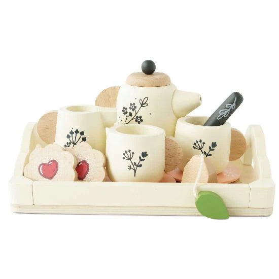 Children's tea set with teapot, cups, and cookies on a white background