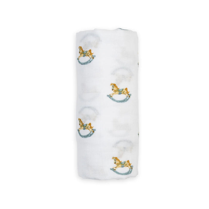 White cotton muslin blanket with rocking horse designs on a white background