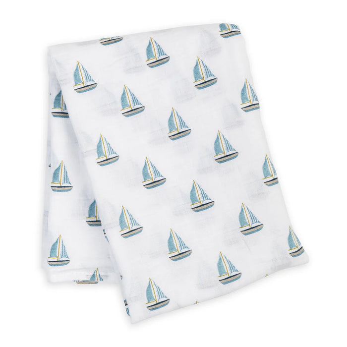White folded cotton swaddling blanket with blue sailboat pattern on a white background