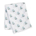White folded cotton swaddling blanket with blue sailboat pattern on a white background