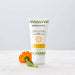 Tube of 'substance' sunscreen cream with an orange flower on a white background