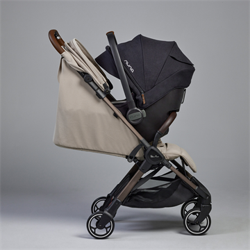 Beige and black stroller with Nuna branding on a gray background
