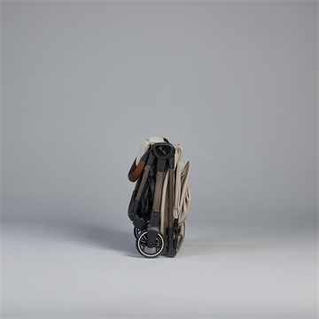 Compact scooter folded and placed on a gray background