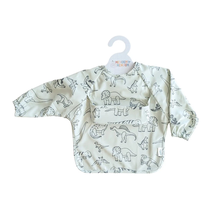 A long-sleeve baby bib with an all-over dinosaur line art print on a light cream background, hanging on a white plastic hanger against a plain white background.