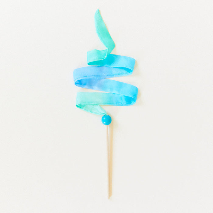 Blue ribbon on a wooden stick against a white background