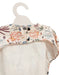 Floral-patterned baby romper on a hanger against a white background