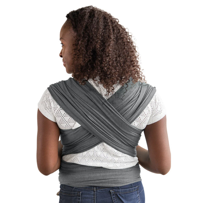 Woman wearing a gray wrap carrier on a white background