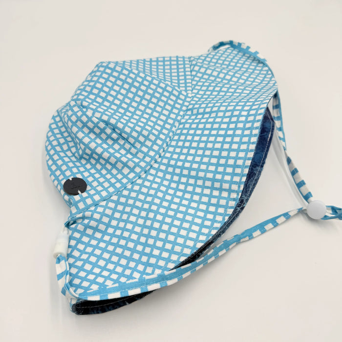 Blue and white checkered sun hat on a light gray background