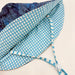 Blue and white checkered fabric with a strap on a beige background