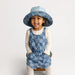 Child wearing a reversible checkered sun hat on a white background