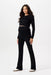 Woman wearing a black long-sleeve top and black flared maternity pants on a white background