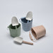 Set of colorful buckets and shovels on a light gray background