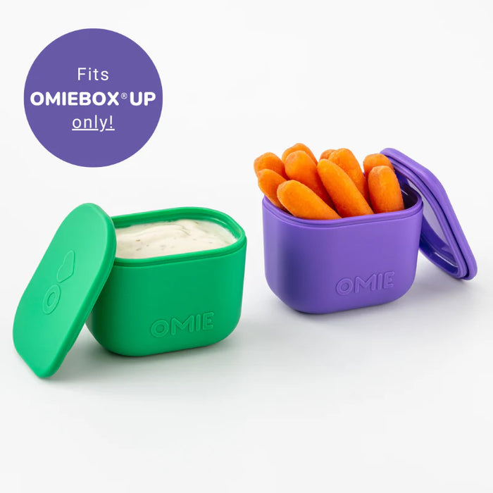 Two OMIE UP containers, one green and one purple, with carrots and dip on a white background.