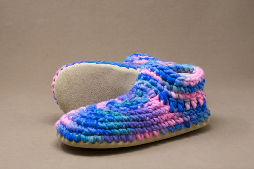 Multicolored crocheted slipper on a brown background