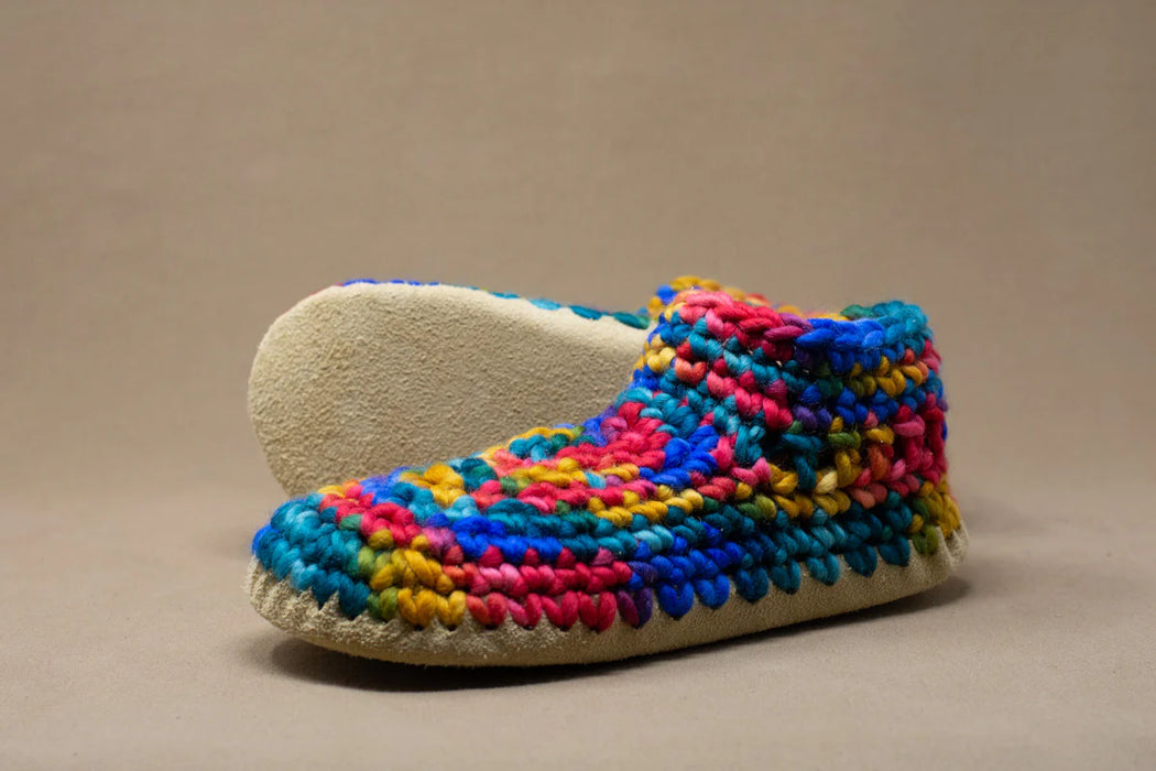 Colorful crocheted slipper on a beige background