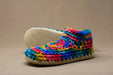 Colorful crocheted slipper on a beige background
