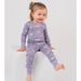 Child wearing a purple pajama set with animal prints on a light gray background