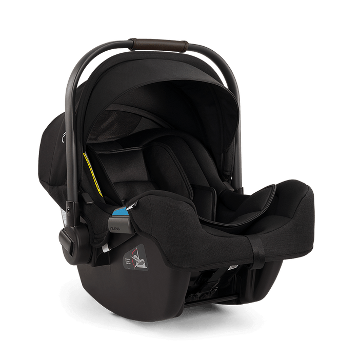 A black infant car seat with a  dark brown handle grip, shown from a three-quarters angle on a white background.