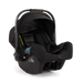A black infant car seat with a  dark brown handle grip, shown from a three-quarters angle on a white background.