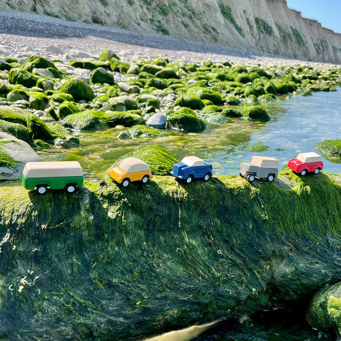 Set of 5 wooden toy cars set on a nature trail