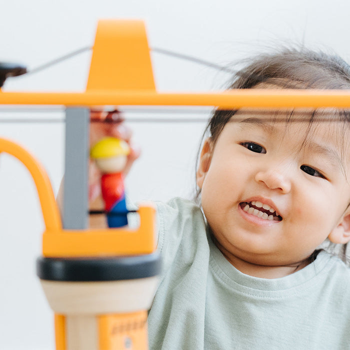 Child playing with a toy ladder in a bright room