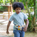 Child wearing a toy belt with various attachments outdoors