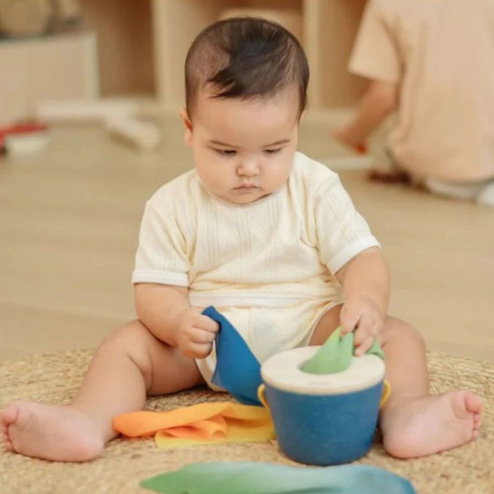 baby playing with colourful toy on floor