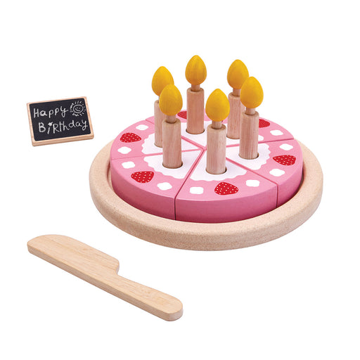 Toy birthday cake with candles and a wooden knife on a white background
