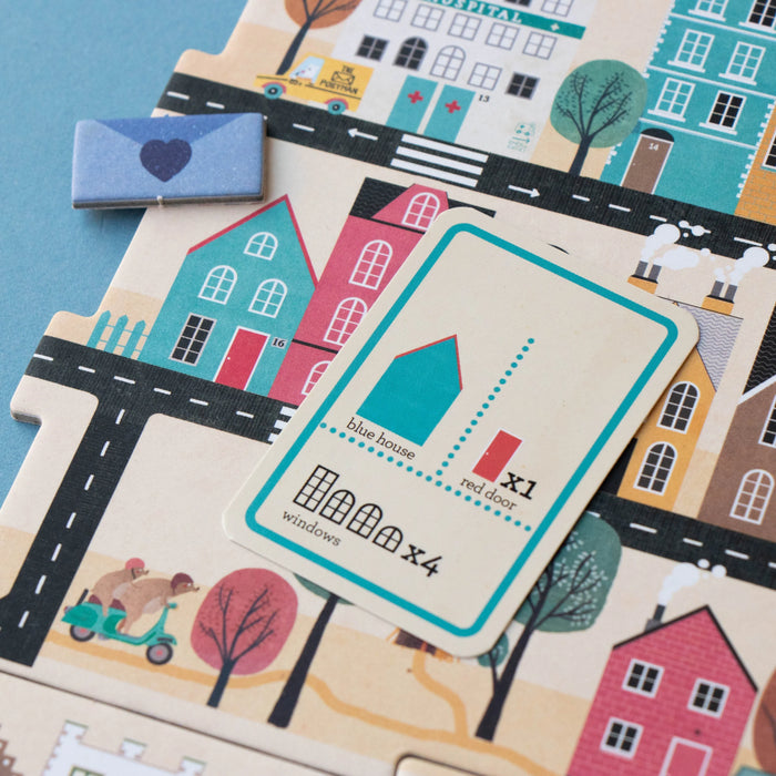 Children's toy with house cards and a blue envelope on a colorful street layout
