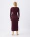Woman wearing a burgundy ribbed dress on a white background