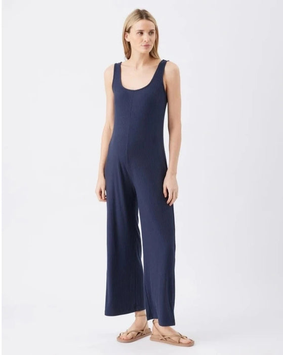 Woman wearing a navy blue maternity jumpsuit on a white background