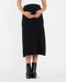 Person wearing a black skirt and black boots on a white background