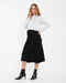 Woman wearing a white sweater and black skirt on a white background