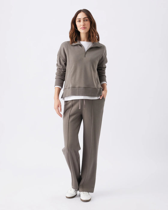 Woman wearing a gray tracksuit on a white background