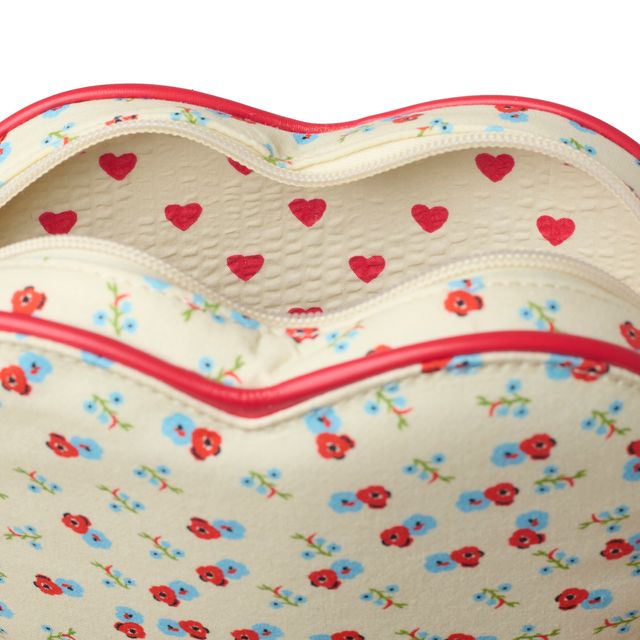 Close-up of a heart-shaped bag with a cream background, red and blue floral print, and red trim, shown open against a white background.