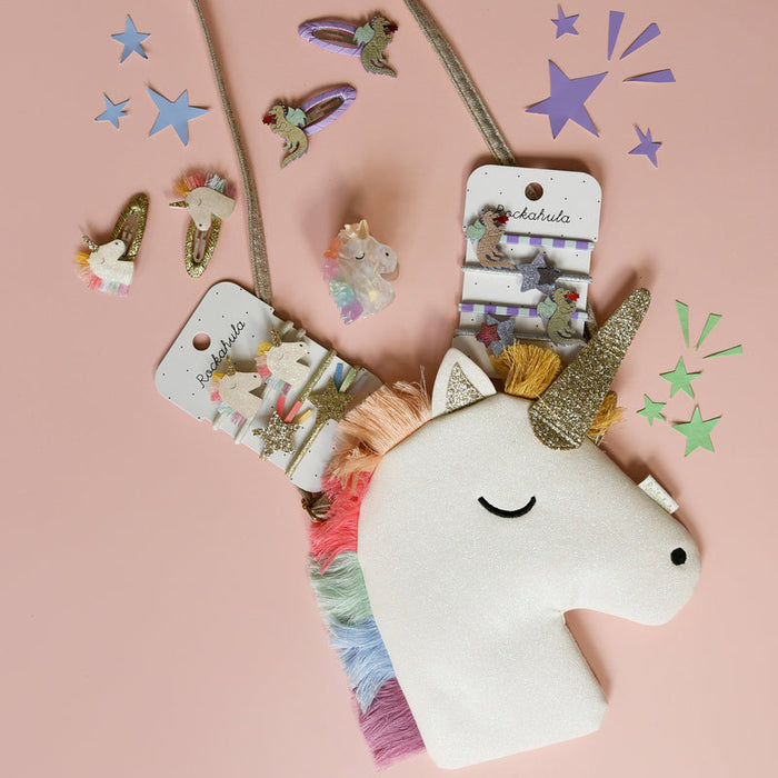 Unicorn-shaped hair accessories to match with unicorn children's purse on a pink background