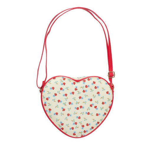 A heart-shaped crossbody bag with a red strap and red trim, featuring a cream background with a small red and blue floral pattern.