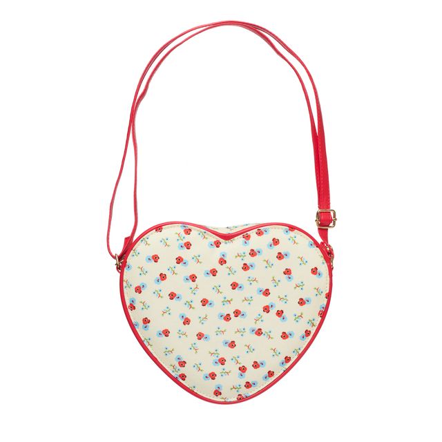 A heart-shaped crossbody bag with a red strap and red trim, featuring a cream background with a small red and blue floral pattern.