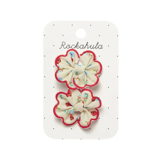 Two scalloped flower hair clips with cream centers, red borders, and small multicolor florals, displayed on a white card labeled Rockahula.