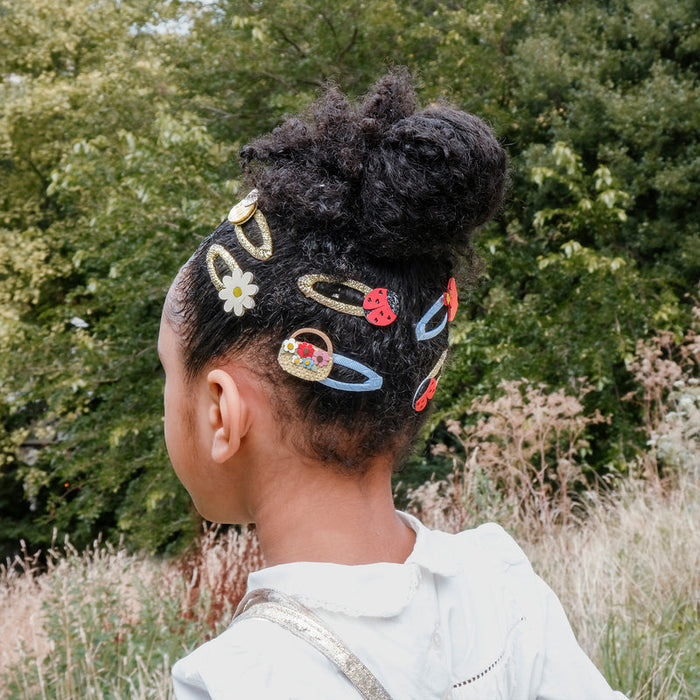 Child with styled hair featuring colorful hair accessories outdoors