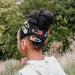 Child with styled hair featuring colorful hair accessories outdoors