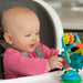 child sitting in highchair playing with teething toy