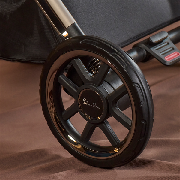 Close-up of a stroller wheel with a visible brand logo on a brown background
