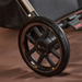 Close-up of a stroller wheel with a visible brand logo on a brown background