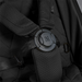 Close-up of a black car seat with straps and a visible brand logo.