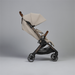 Beige stroller with wooden handles on a gray background